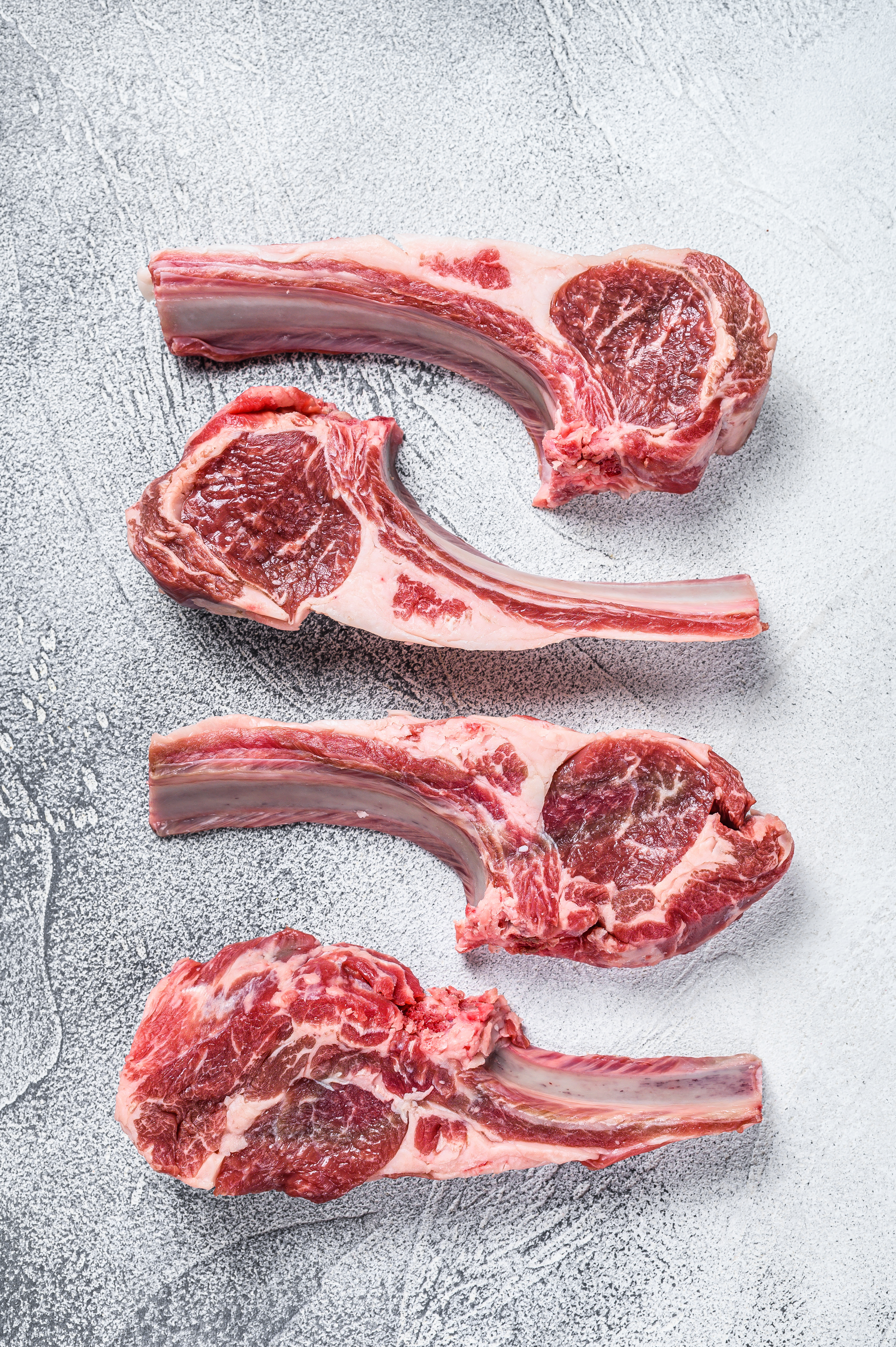 Raw lamb meat chops on a butcher table. White background. Top view